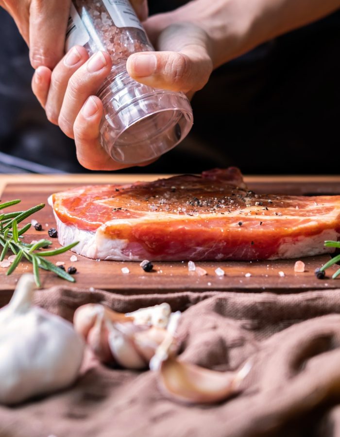 Chef prepares pork chop steak with barbecue sauce in the kitchen